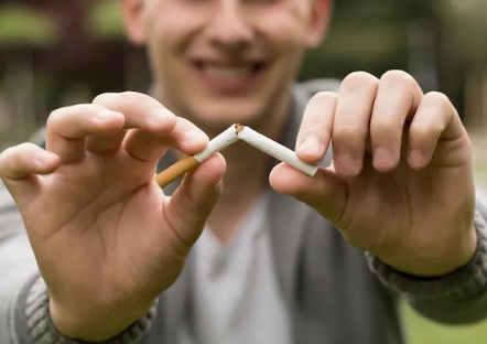 Persona rompiendo un cigarrillo como símbolo de dejar de fumar